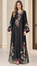 Front full-length view of model wearing black embroidered maxi kaftan dress with bell sleeves