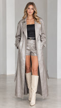 Full-length front view of model wearing metallic silver croc-embossed maxi trench coat