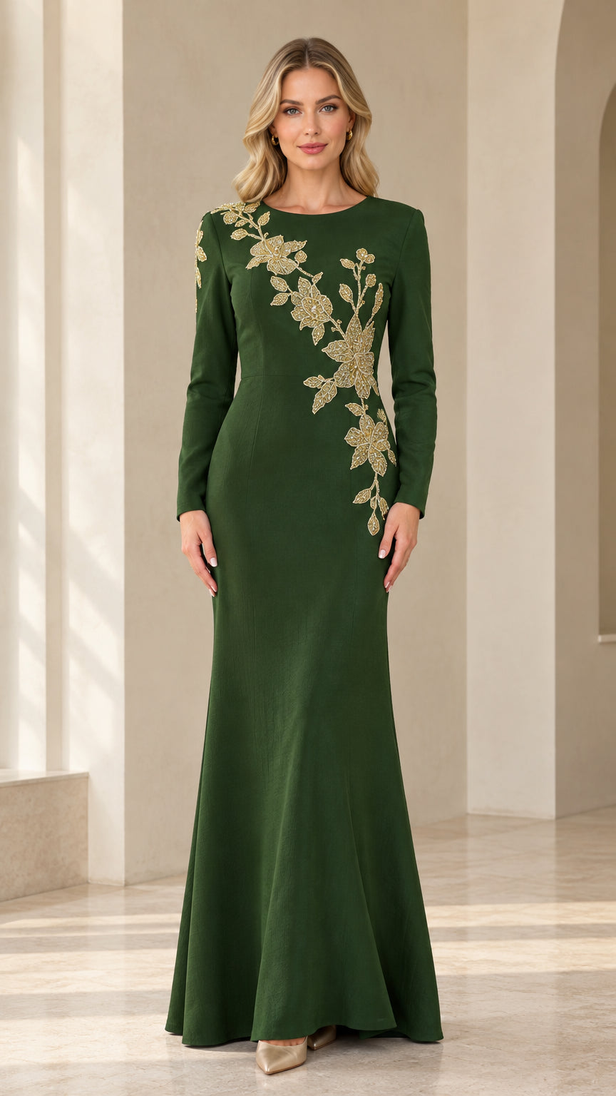 Front view of model wearing emerald green long sleeve evening gown with gold floral embroidery