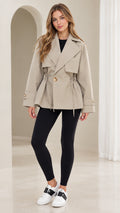 Front view of model wearing khaki short drawstring waist trench jacket with black pants