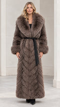Front view of woman wearing taupe brown chevron faux fur maxi coat with black belt