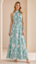 Front view of woman wearing sage green floral halter neck maxi dress