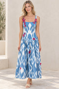 Front view of model wearing blue and white ikat print square neck maxi dress with pink butterfly appliques