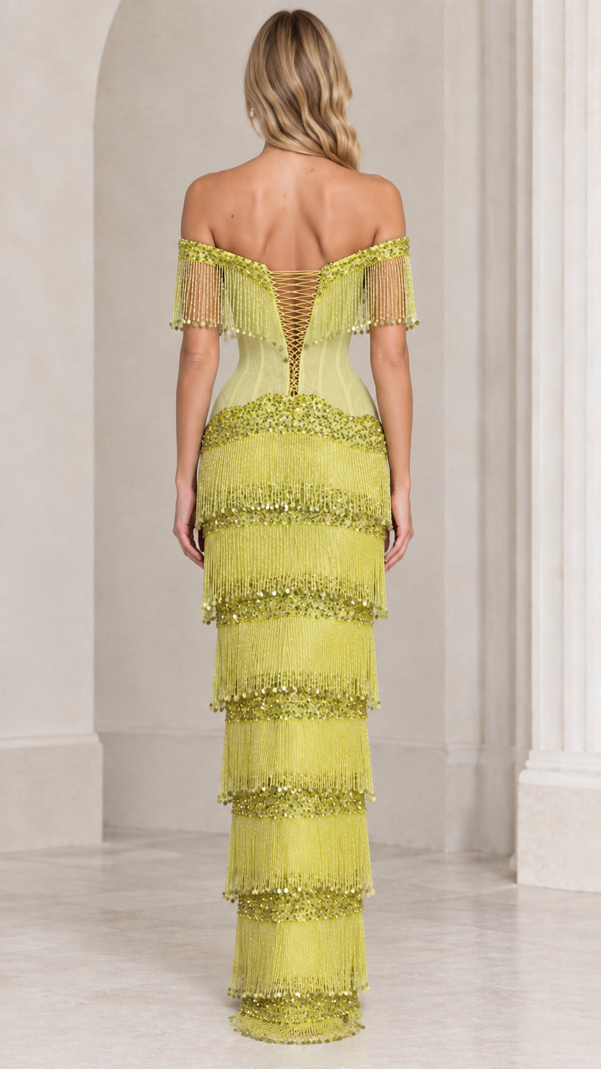 Back view of chartreuse gown highlighting lace-up corset back and tiered fringe