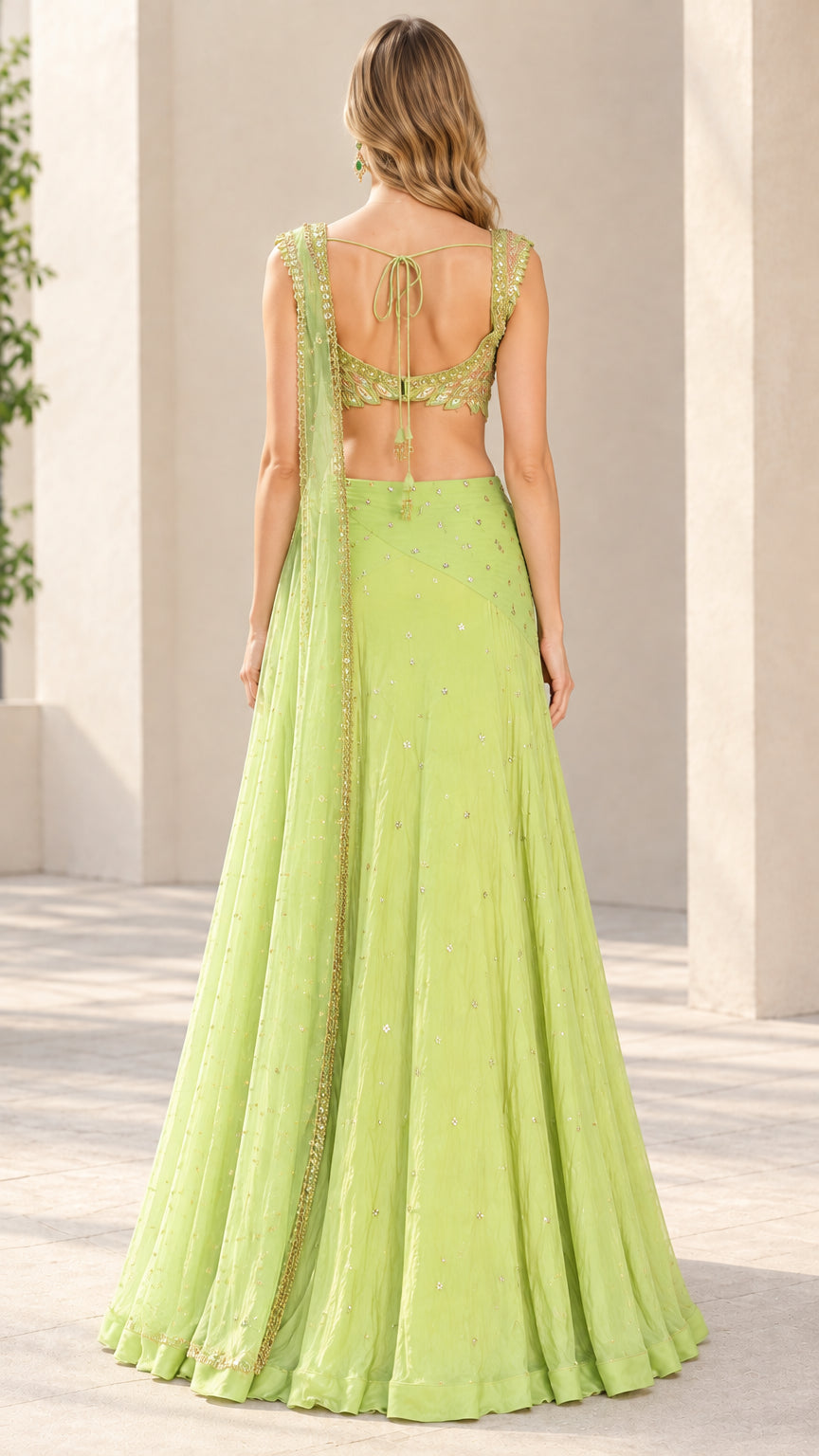 Back view of model wearing lime green tie-back lehenga choli blouse and skirt