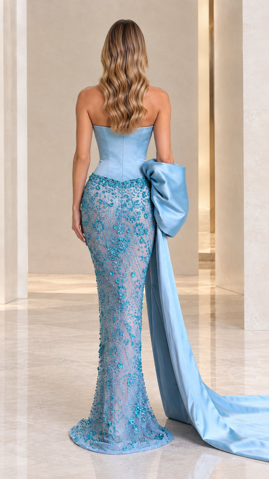 Back view of sky blue strapless gown showing contoured fit and statement draped train