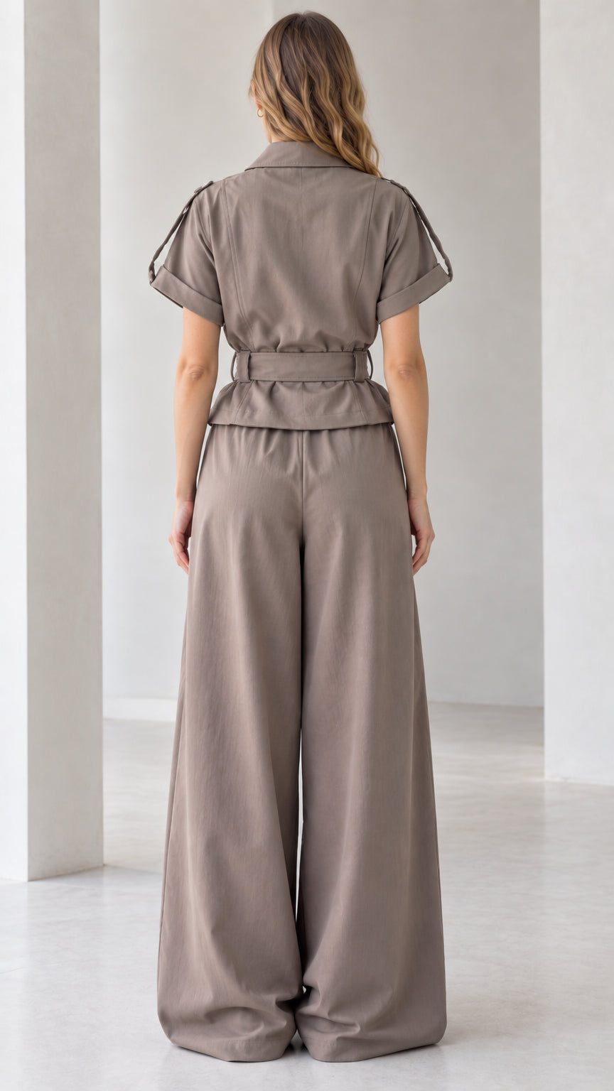 Back full-length view of taupe wide leg jumpsuit showing relaxed silhouette