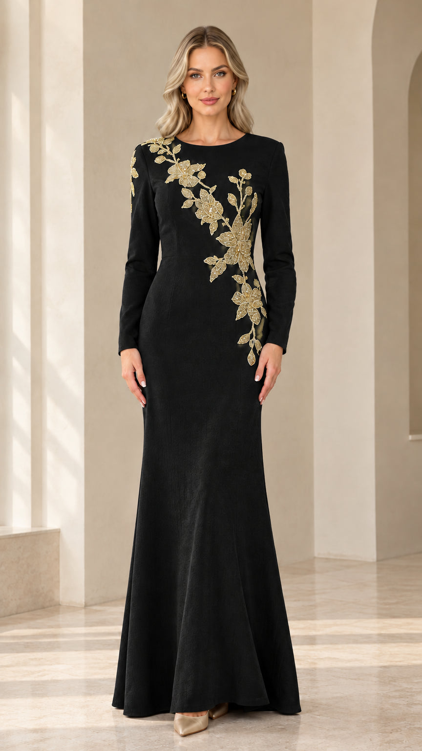 Model wearing black long sleeve evening gown with gold floral embroidery
