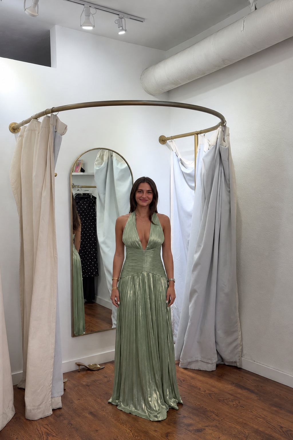 Front view of model wearing sage green metallic pleated halter maxi evening gown